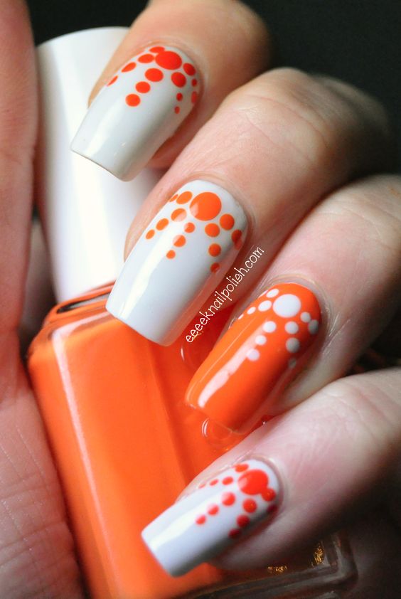 Orange and white polka dots diverging nail art