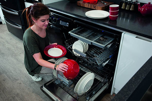 A lady arranging the cleaned utensils in the closet