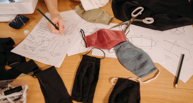 A woman drawing a sketch for different sewing patterns.
