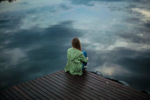 Solitary woman with PTSD, sitting in contemplation.