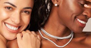 Elegant women showcasing a sparkling diamond tennis necklace gracefully.