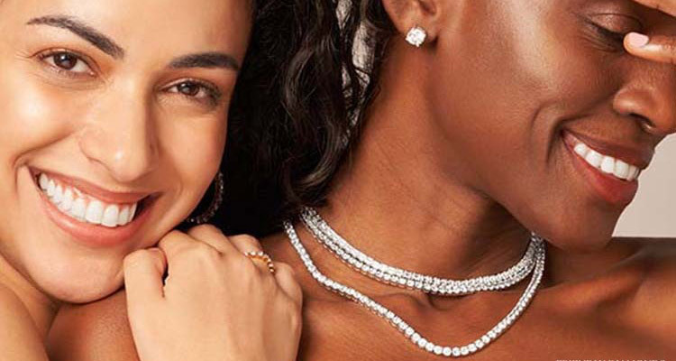 Elegant women showcasing a sparkling diamond tennis necklace gracefully.