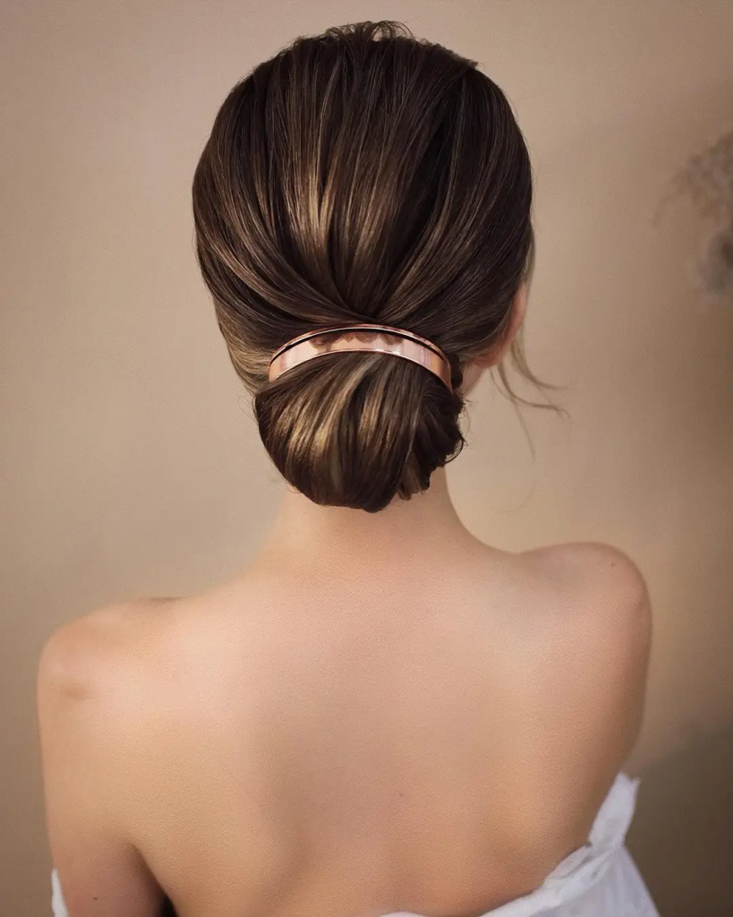 Effortless chic: A smooth low bun, a classic and stylish choice for any occasion.