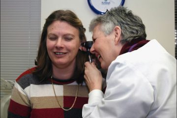 A professional performing professional ear wax removal for a patient, ensuring optimal ear health