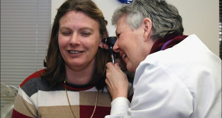 A professional performing professional ear wax removal for a patient, ensuring optimal ear health