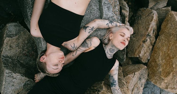 Two women showcasing the hottest tattoo trends, each adorned with unique inked designs that reflect their individual style and personality.