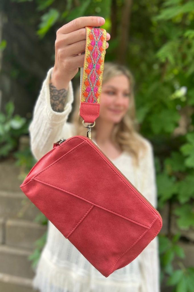 Compact wristlet with a sleek design and a convenient wrist strap.